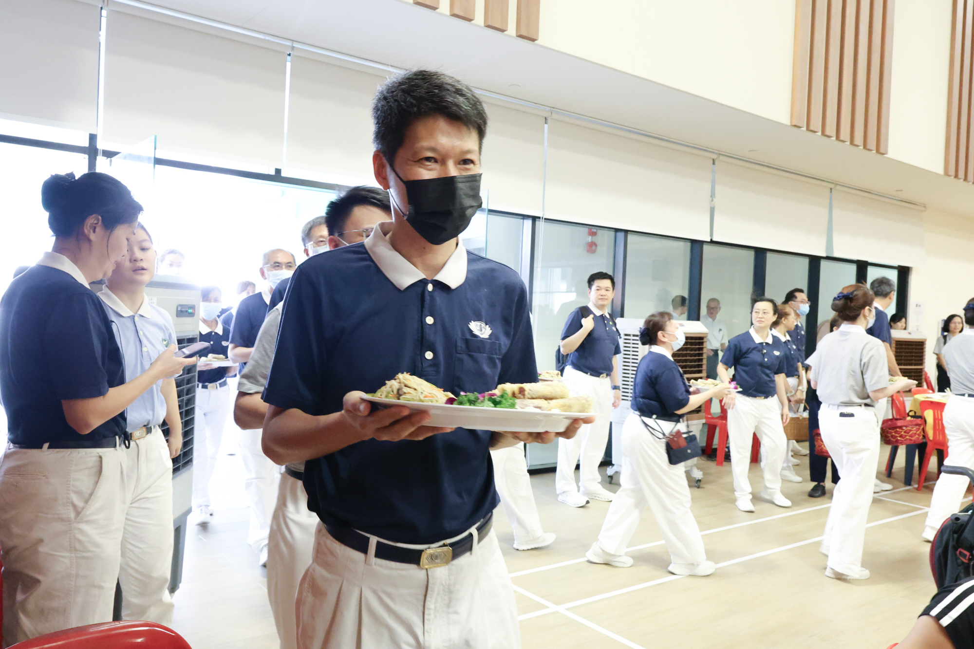 年菜一道接一道，桌长们列队奉上佳肴。摄/ 倪志豪