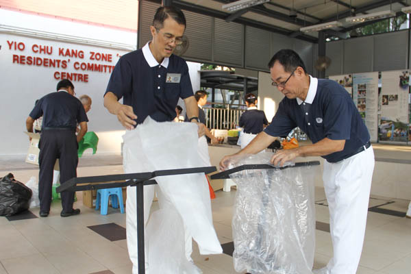 The “recycling frame,” invented by volunteer Hong De Qian, is a versatile piece of furniture which can be folded and stacked to function as a table or used as a frame holding up plastic bags containing different types of recyclables. Photo by Chua See Siew