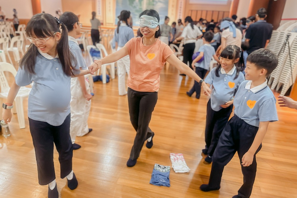 接下来的亲子互动环节,更考验彼此之间的信任,由孩子引领蒙上双眼的父母,在双方不靠言语只运用触感和手势的情况下,合作进行各项任务挑战。(摄/ 许金龙)
